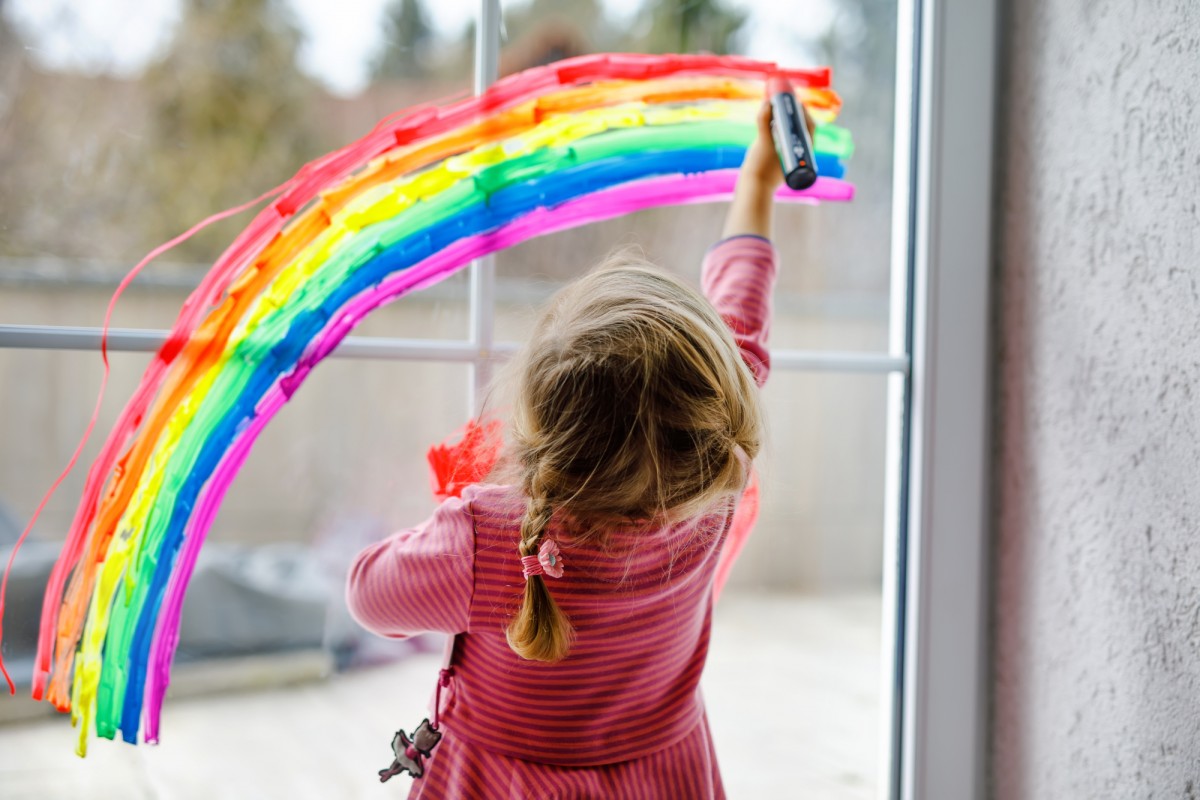 Kind malt einen Regenbogen